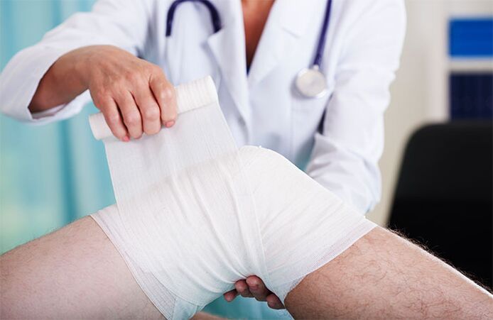 lekár obväzuje kolenný kĺb s artrózou